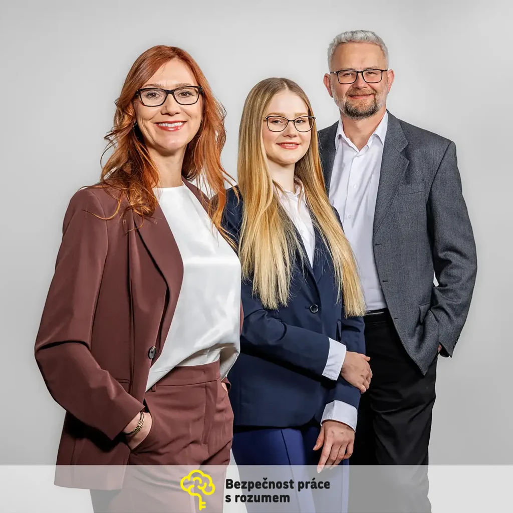 Skupinový firemní portrét tří členů týmu v business oblečení na neutrálním pozadí